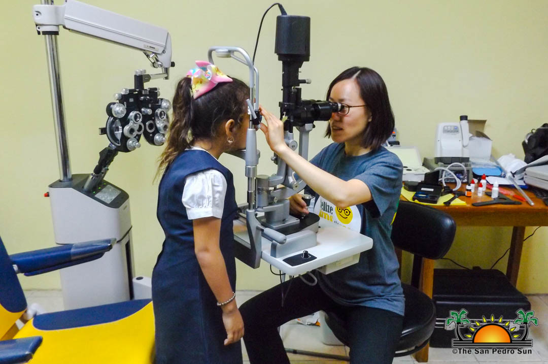A clinician performing an eye examination for a student at the Stanford Belize Vision Clinic